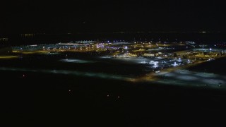 AXSF07_102 - 5K aerial stock footage reverse view of Oakland International Airport, Oakland, California, night