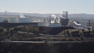 AXSF08_019 - 5K aerial stock footage of ConocoPhillips Oil Refinery, light traffic passing by, Rodeo, California