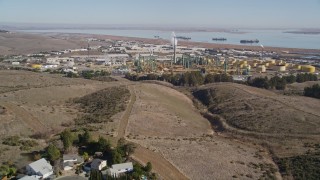 AXSF08_032 - 5K aerial stock footage of flying over tract homes, revealing Valero Oil Refinery, Benicia, California