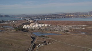 AXSF08_054 - 5K aerial stock footage of flying by oil refinery, Benicia-Martinez Bridge, Copart Auction, Martinez, California