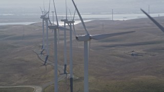 AXSF08_074 - 5K aerial stock footage orbit top of windmill, reveal and flyby row of windmills, Shiloh Wind Power Plant, California