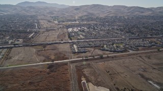 AXSF08_085 - 5K aerial stock footage of approaching a train passing suburban houses, Pittsburg, California