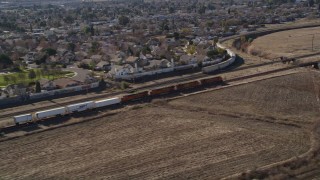 AXSF08_087 - 5K aerial stock footage of tracking train traveling by suburban area, fields, Pittsburg, California