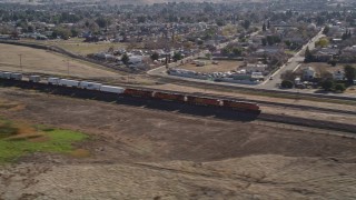 AXSF08_088 - 5K aerial stock footage of flying by a train traveling past residential neighborhoods, Pittsburg, California