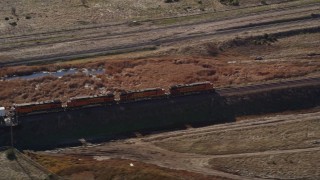 AXSF08_092 - 5K aerial stock footage of tracking the engines of a train as it moves past fields, Pittsburg, California