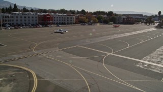 AXSF08_096 - 5K aerial stock footage of passing hangars at Buchanan Field Airport, orbit red plane in Concord, California