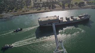 AXSF09_021 - 5K aerial stock footage of tilting from Oakland Inner Harbor to reveal and track a cargo ship in Port of Oakland, California