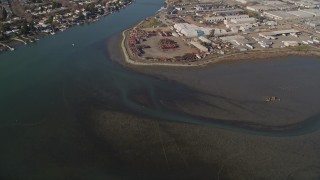 AXSF09_072 - 5K aerial stock footage of flying away from warehouse buildings by the Oakland Estuary and over San Leandro Bay, Oakland, California