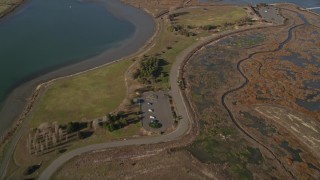 AXSF09_074 - 5K aerial stock footage of a reverse view of roads through marshland and San Leandro Bay, California