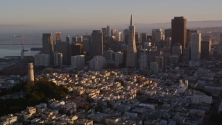 AXSF10_026 - 5K aerial stock footage orbit Coit Tower, tilt to reveal downtown skyline, Downtown San Francisco, California, sunset