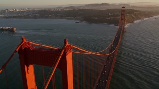 AXSF10_033 - 5K aerial stock footage of flying over Golden Gate Bridge, reveal cargo ship, San Francisco, California, sunset