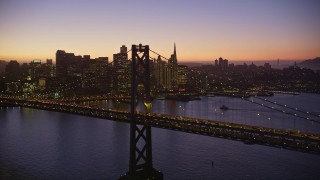 AXSF10_103 - 5K aerial stock footage flying by the Bay Bridge, skyline in the background, Downtown San Francisco, California, twilight