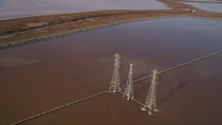 AXSF11_017 - 5K aerial stock footage of flying by power lines and Mowry Slough marshlands, Newark, California