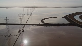 AXSF11_021 - 5K aerial stock footage of flying by power lines and marshlands, Sunnyvale, California