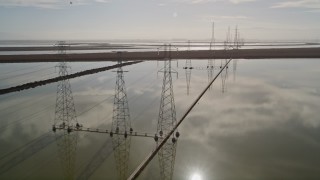 AXSF11_023 - 5K aerial stock footage of flying by a row of power lines and marshlands, Sunnyvale, California