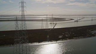 AXSF11_027 - 5K aerial stock footage of flying over power lines through marshlands, Sunnyvale, California