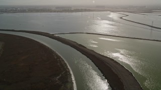 AXSF11_029 - 5K aerial stock footage of flying over marshland, pan across sloughs and power lines, Sunnyvale, California