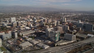 AXSF12_003 - 5K aerial stock footage tilt from Target rooftop to reveal and fly over Highway 87 and Downtown San Jose high rises, California