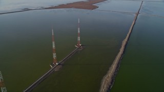 AXSF12_070 - 5K aerial stock footage of flying by wetlands, tilt down revealing radio towers, Fremont, California