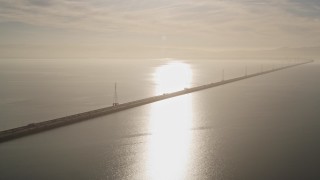 AXSF12_081 - 5K aerial stock footage of flying by San Mateo Bridge, sun reflecting off San Francisco Bay, California