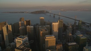 AXSF14_009 - 5K aerial stock footage tilt to reveal and fly over skyscrapers in Downtown San Francisco, California, and approach the Bay Bridge, twilight