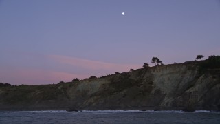 AXSF14_050 - 5K aerial stock footage approach and flyby coastal cliffs with the moon above, San Francisco, California, twilight