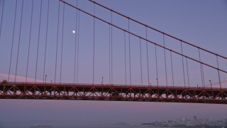 AXSF14_056 - 5K aerial stock footage of flying by the Golden Gate Bridge with a view of the moon, San Francisco, California, twilight