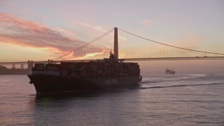 AXSF14_068 - 5K aerial stock footage fly over a cargo ship to approach the Golden Gate Bridge, San Francisco, California, twilight