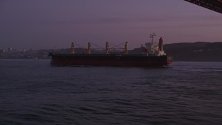 AXSF14_072 - 5K aerial stock footage approach oil tanker sailing under Golden Gate Bridge, San Francisco, California, twilight