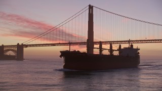 AXSF14_074 - 5K aerial stock footage of flying by famous Golden Gate Bridge, reveal oil tanker, San Francisco, California, twilight