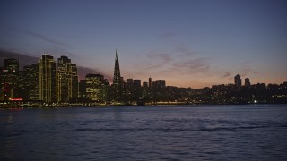 AXSF14_103 - 5K aerial stock footage low flyby of Transamerica Pyramid and Downtown San Francisco skyline, reveal the Ferry Building, California, twilight