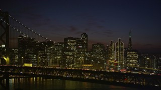 AXSF14_133 - 5K aerial stock footage of Downtown San Francisco skyline seen while passing by the Bay Bridge, California, night