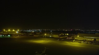 AXSF14_137 - 5K aerial stock footage a view of hangars while descending at Oakland International Airport, California, night