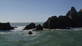AXSF15_043 - 5K aerial stock footage of flying low over rock formations, Pacifica, California