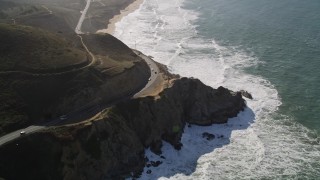 AXSF15_045 - 5K aerial stock footage video of following Highway 1 along the coast, winding above cliffs, Montara, California