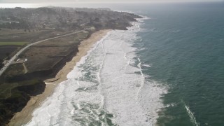 AXSF15_046 - 5K aerial stock footage of flying over Montara State Beach, tilt revealing coastal neighborhoods, Montara, California