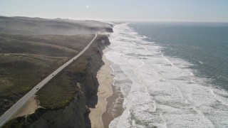 AXSF15_066 - 5K aerial stock footage of tilting from the coastal beach revealing Highway 1, San Gregorio, California