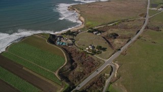 AXSF15_082 - 5K aerial stock footage of a reverse view of Highway 1 on the coast, revealing crop fields, Davenport, California