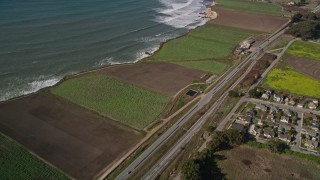 AXSF15_083 - 5K aerial stock footage of flying away from Highway 1 along the coast and crop fields, Davenport, California