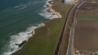 AXSF15_086 - 5K aerial stock footage of a reverse view of Highway 1 coastal road and train tracks, Davenport, California