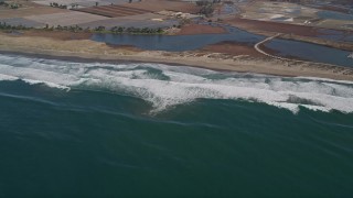 AXSF15_112 - 5K aerial stock footage of flying by waves rolling toward a beach, Moss Landing, California