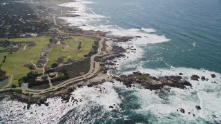 AXSF16_014 - 5K aerial stock footage of Pacific Grove Municipal Golf Links and waves crashing on the coast by Ocean View Boulevard, Pacific Grove, California