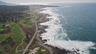 AXSF16_019 - 5K aerial stock footage tilt from kelp to reveal Pacific Grove Municipal Golf Links, and Ocean View Boulevard on the coast, Pacific Grove, California