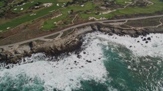 AXSF16_020 - 5K aerial stock footage of 17 Mile Drive coastal road and golf course near homes in Pebble Beach, California
