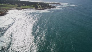 AXSF16_022 - 5K aerial stock footage tilt from waves crashing into rock formations to reveal Cypress Point Golf Course, Pebble Beach, California