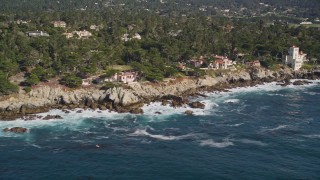 AXSF16_027 - 5K aerial stock footage of passing by oceanfront mansions on the coast, Pebble Beach, California