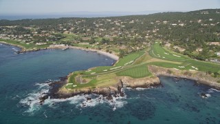AXSF16_034 - 5K aerial stock footage tilt from the ocean to reveal a golf course and resort on the coast in Pebble Beach, California