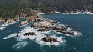 AXSF16_049 - 5K aerial stock footage of flying by rugged coastline with trees and rock formations, Carmel, California