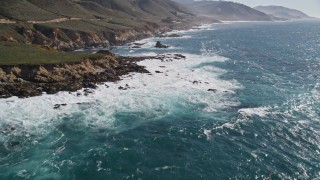 AXSF16_057 - 5K aerial stock footage of flying over kelp near waves crashing against coastal cliffs, Carmel, California