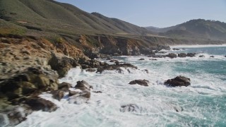 AXSF16_061 - 5K aerial stock footage of flying over waves crashing into the coastal cliffs and rock formations, Carmel, California